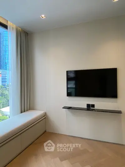 Modern living room with wall-mounted TV and large window offering city view