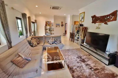 Spacious living room with modern decor and large TV, perfect for family gatherings.