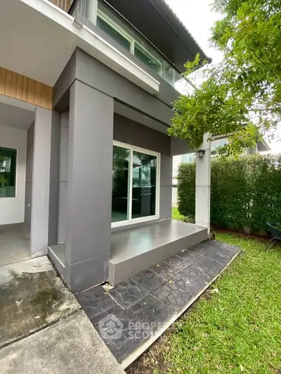 Modern two-story home exterior with sleek design and lush green surroundings.