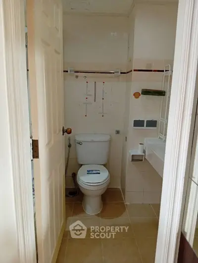 Compact bathroom with modern fixtures and tiled walls, ideal for efficient space utilization.