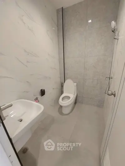 Modern minimalist bathroom with sleek fixtures and elegant tile design.