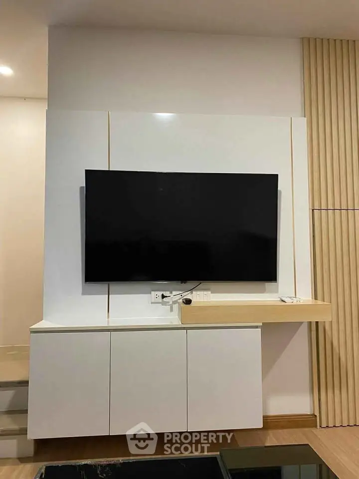 Modern living room with sleek TV unit and stylish wooden paneling