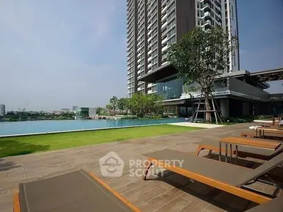 Luxurious high-rise building with poolside relaxation area and stunning city views.
