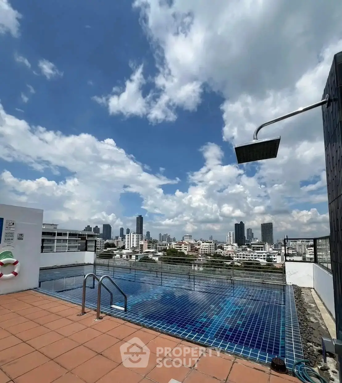 Stunning rooftop pool with city skyline views under a clear blue sky.