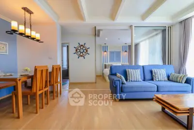 Spacious living room with blue sofa and dining area in modern apartment