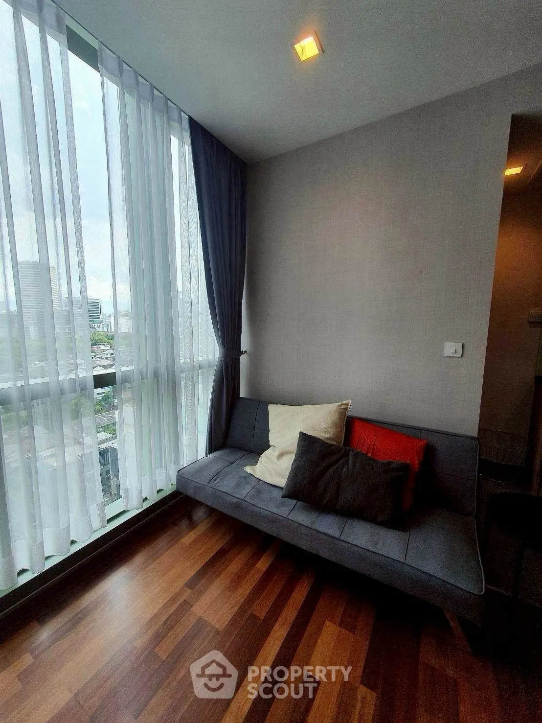 Stylish corner unit with floor-to-ceiling windows and cozy seating area.