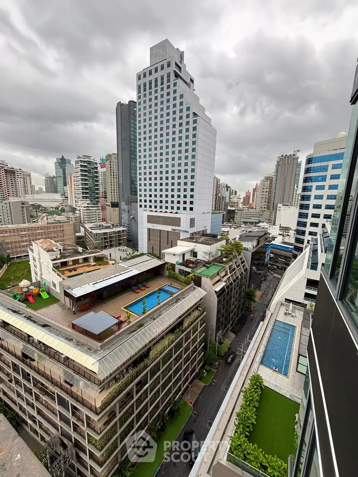Stunning cityscape view with modern high-rise buildings and rooftop pools, perfect for urban living.