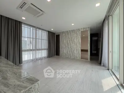 Spacious modern living room with large windows and elegant marble accents