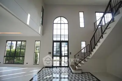 Spacious modern living room with high ceilings and elegant staircase
