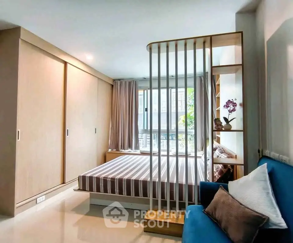 Modern bedroom with stylish partition and large window in a cozy apartment