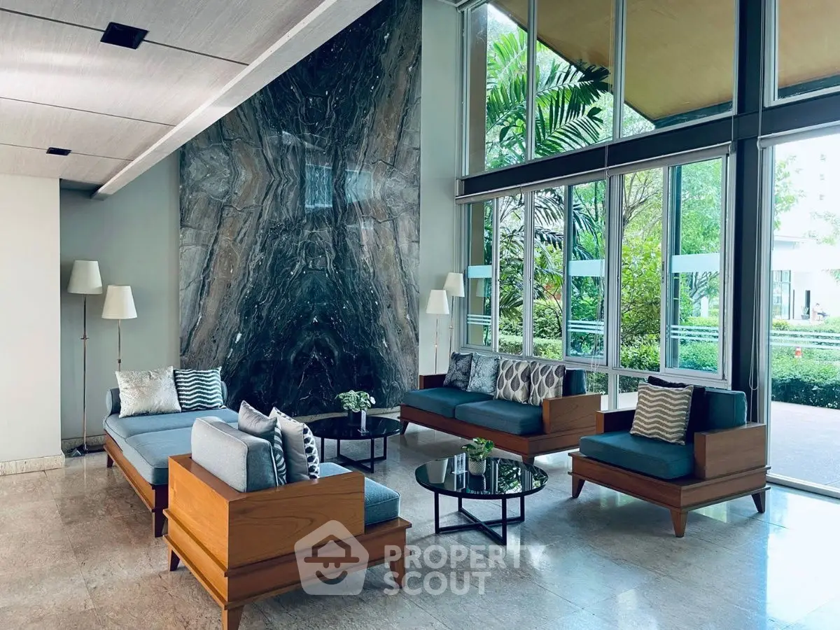 Luxurious modern living room with elegant furniture and large windows overlooking a lush garden.