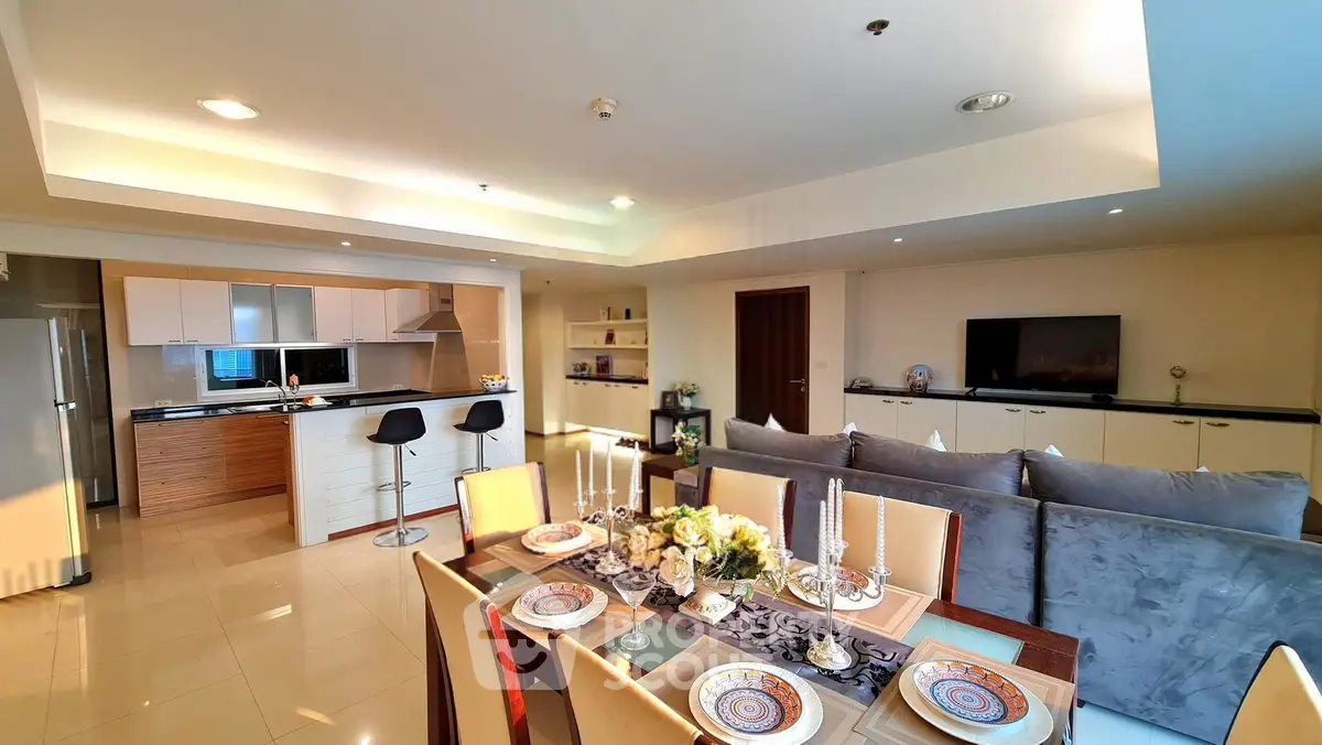 Spacious open-plan living and dining area with modern kitchen and elegant decor.