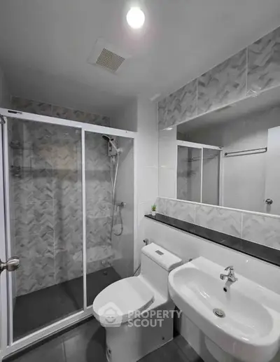 Modern bathroom with glass shower and sleek fixtures in a contemporary home.