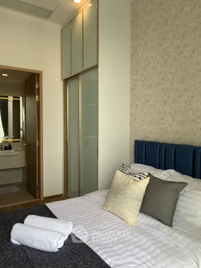 Modern bedroom with elegant decor and view into stylish bathroom