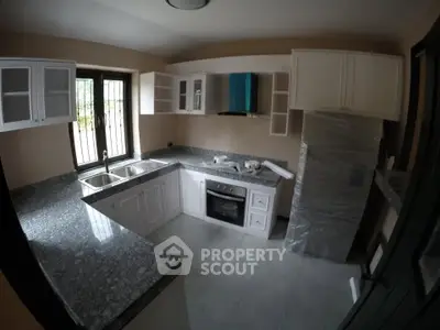 Modern kitchen with granite countertops and built-in oven in a cozy home.