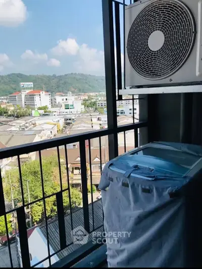 Stunning balcony view with cityscape and mountains, featuring air conditioning unit.