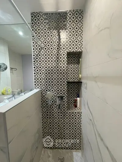 Modern bathroom with stylish geometric tile shower and sleek fixtures