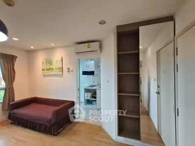 Cozy living room with modern decor and open kitchen layout in a stylish apartment.