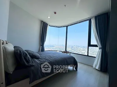 Stunning bedroom with panoramic city view and floor-to-ceiling windows.