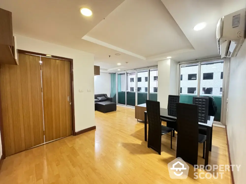 Spacious living room with modern dining area and wooden flooring