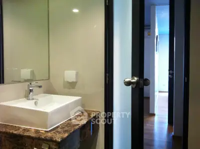 Modern bathroom with sleek sink and marble countertop in a contemporary apartment.