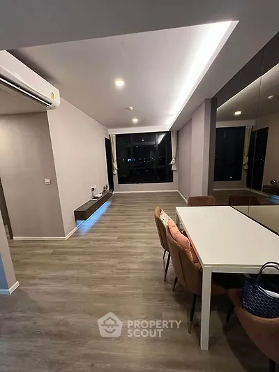 Modern living room with sleek design and large windows offering city views.