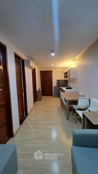 Modern apartment interior with open layout, featuring a cozy living area and dining space.