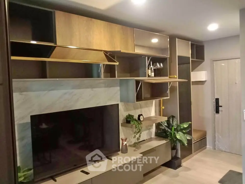 Modern living room with stylish shelving and large TV, featuring elegant decor and ambient lighting.