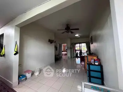 Spacious living area with ceiling fan and tiled flooring in a cozy home