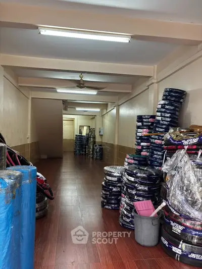Spacious storage area with stacked tires and wooden flooring, ideal for automotive businesses.