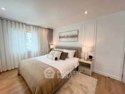 Elegant bedroom with cozy decor and natural light, featuring a comfortable bed and stylish furnishings.