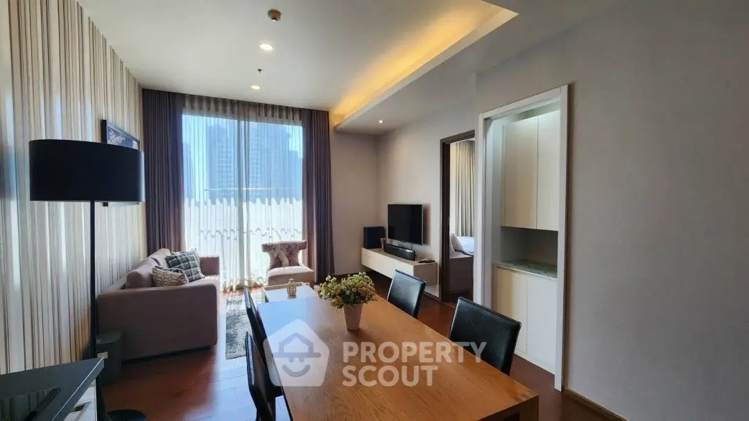 Spacious modern living room with dining area and city view, featuring elegant decor and natural light.