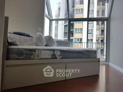 Modern bedroom with large windows and city view, featuring a stylish bed and hardwood floors.