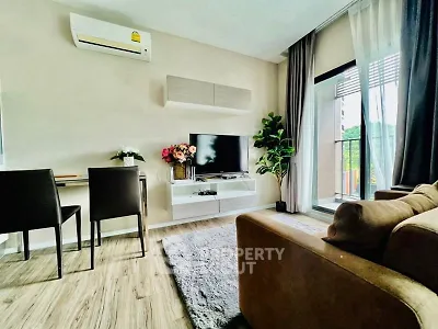 Modern living room with air conditioning, TV, and balcony access, featuring stylish decor and natural light.