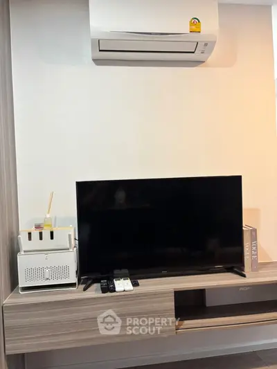 Modern living room with sleek TV setup and air conditioning unit