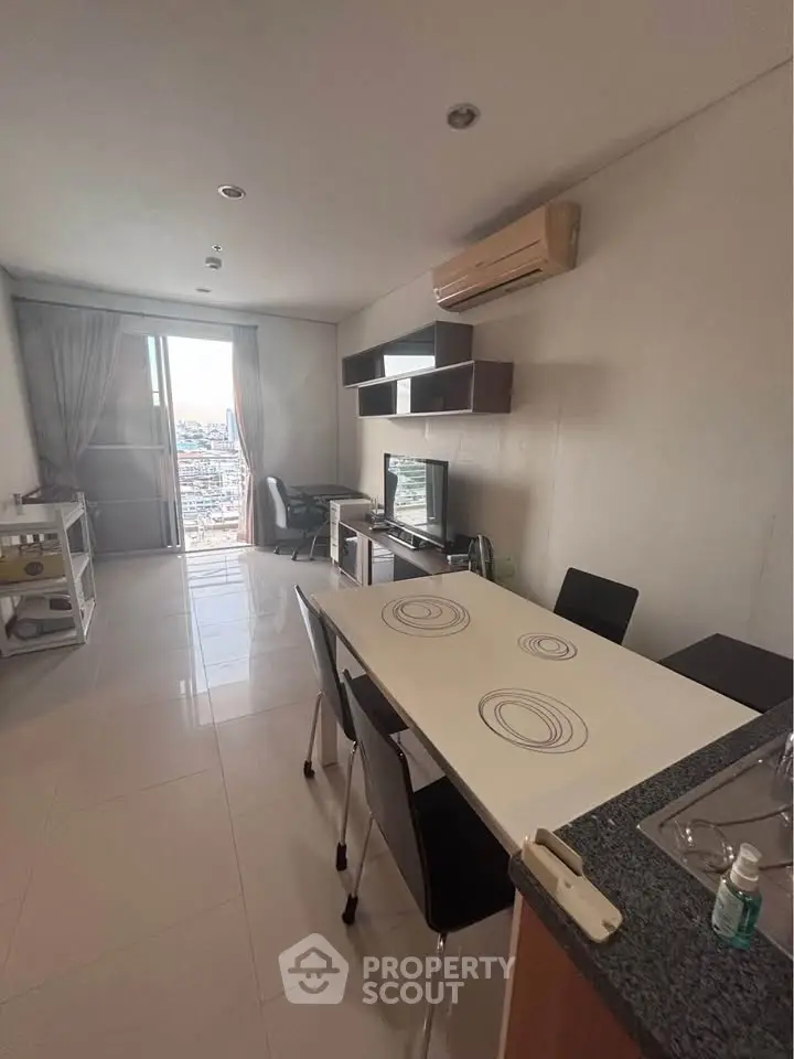 Modern living room with dining area and city view, featuring sleek furniture and air conditioning.
