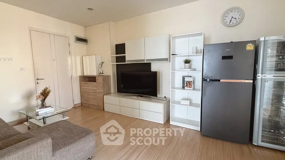 Modern living room with sleek furniture and large TV in stylish apartment.