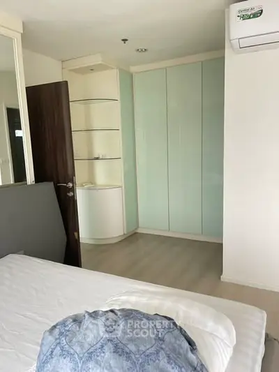 Cozy bedroom with modern design and built-in wardrobe in a stylish apartment.
