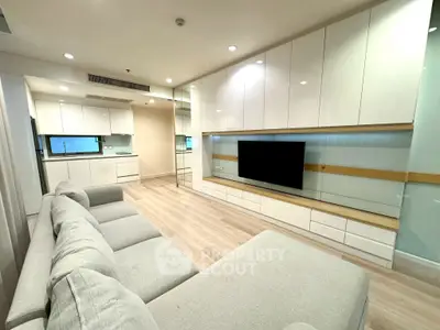 Modern living room with sleek cabinetry and cozy gray sofa