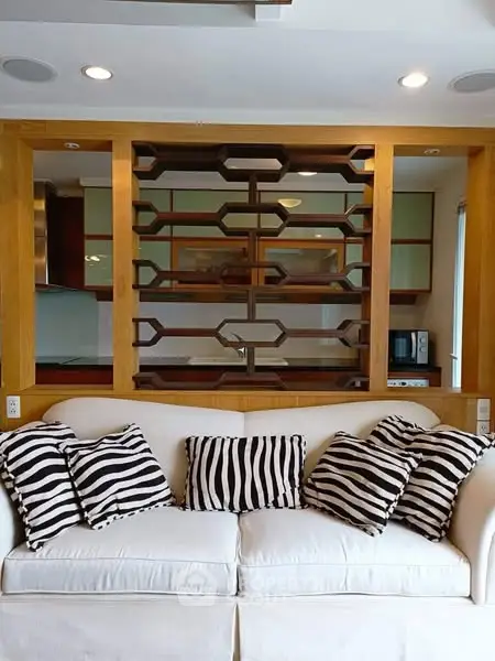 Stylish living room with modern shelving and cozy sofa with zebra print pillows.