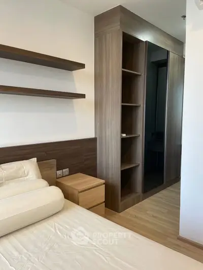 Modern bedroom with sleek wooden shelves and built-in wardrobe