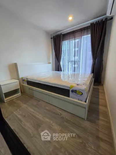 Modern bedroom with large window and stylish curtains in a contemporary apartment.
