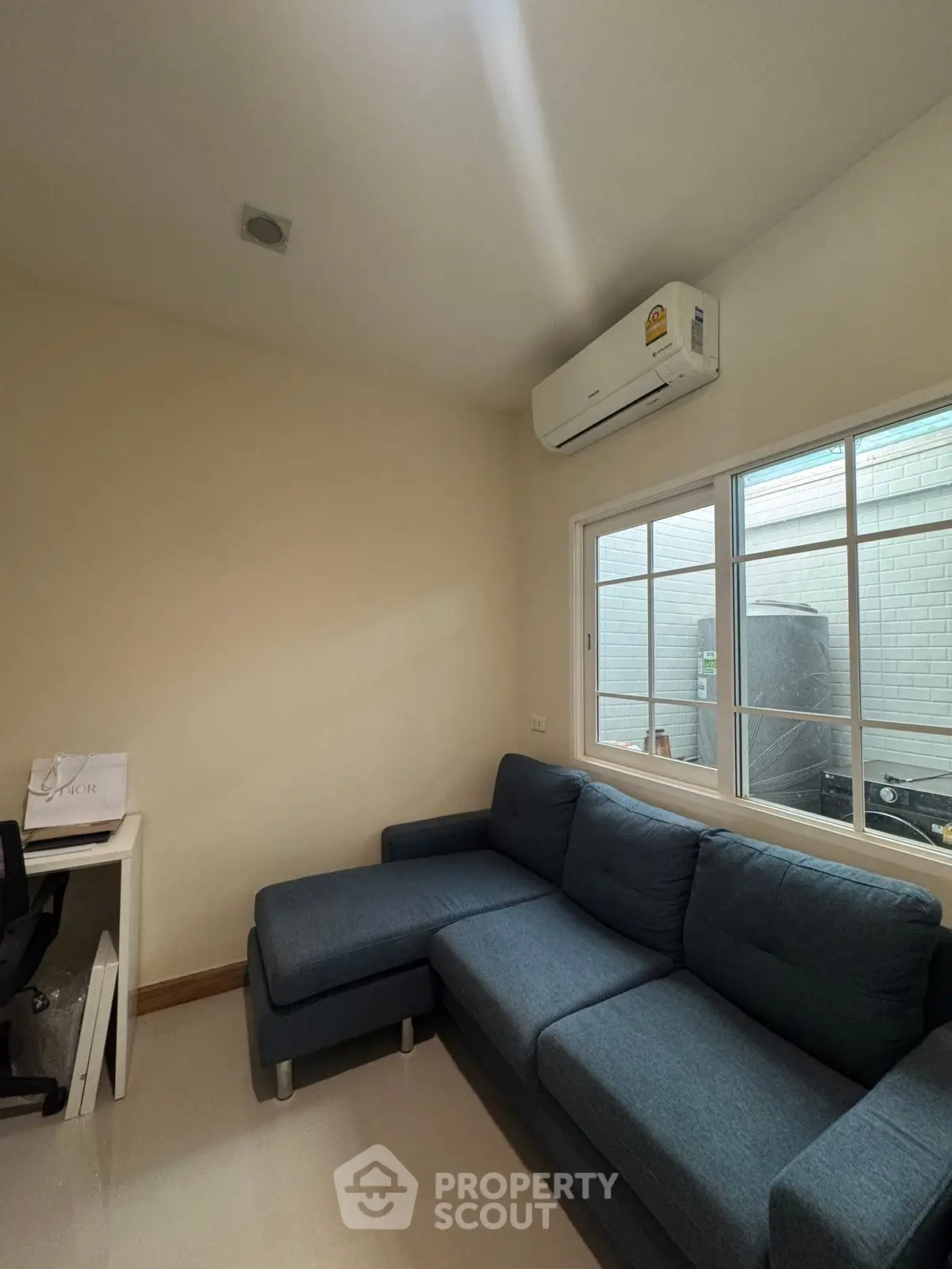 Cozy living room with blue sectional sofa and air conditioning