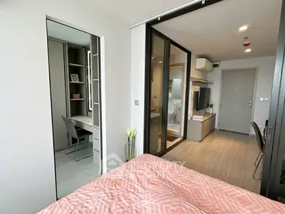 Modern apartment interior with cozy bedroom and study area, featuring sleek design and ample natural light.