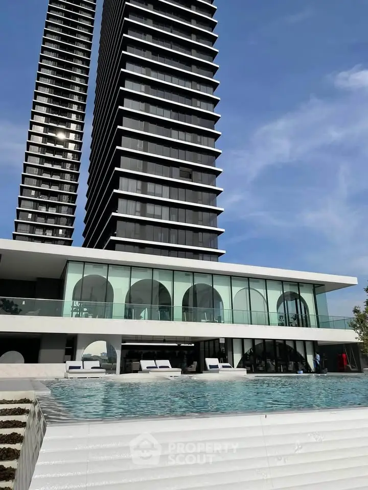 Luxurious modern high-rise building with stunning pool and sleek architectural design.