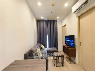 Modern living room with cozy sofa, TV, and stylish decor in a contemporary apartment.
