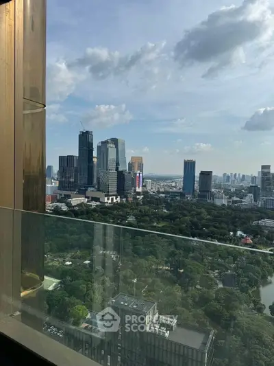 Stunning cityscape view from a high-rise balcony overlooking lush greenery and skyscrapers.
