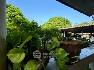 Charming garden view with lush greenery and outdoor parking area, perfect for nature lovers.