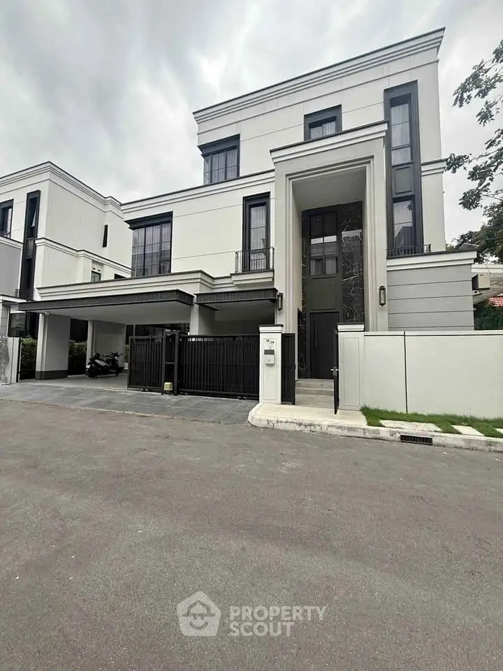 Luxurious modern house with sleek design and spacious driveway in upscale neighborhood.