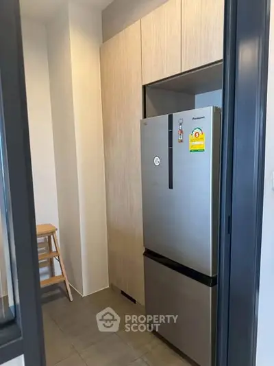 Modern kitchen with sleek stainless steel refrigerator and wooden cabinetry